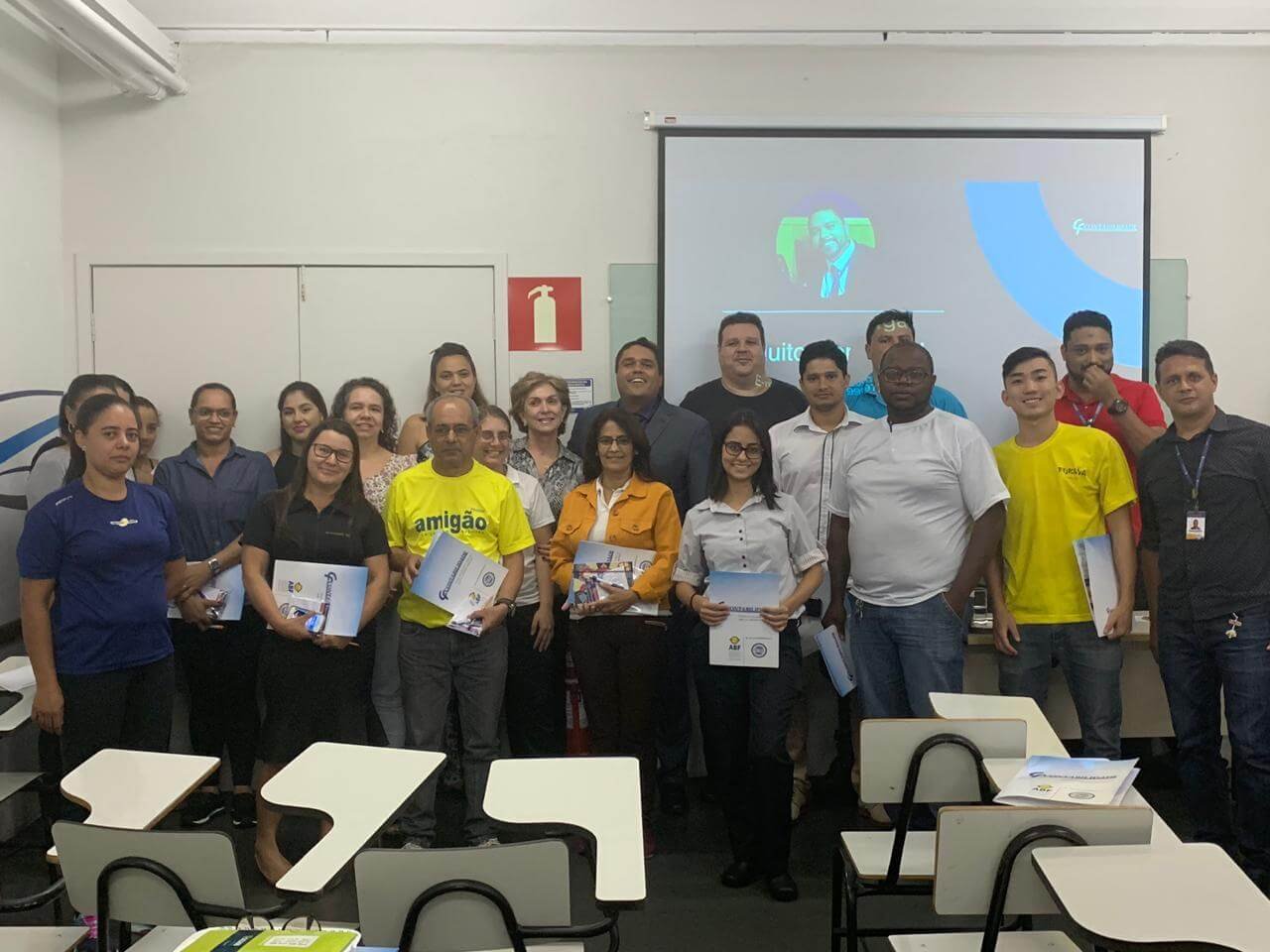 Turma da palestra no Big Shopping reunida em duas fileiras à frente de uma sala. Edilson Júnior, CEO da CF Contabilidade, está ao centro da fileira de trás, vestindo terno escuro.